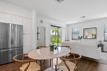 a kitchen with a refrigerator and a table with four chairs at Odyssey, Fort Myers, FL, 33905